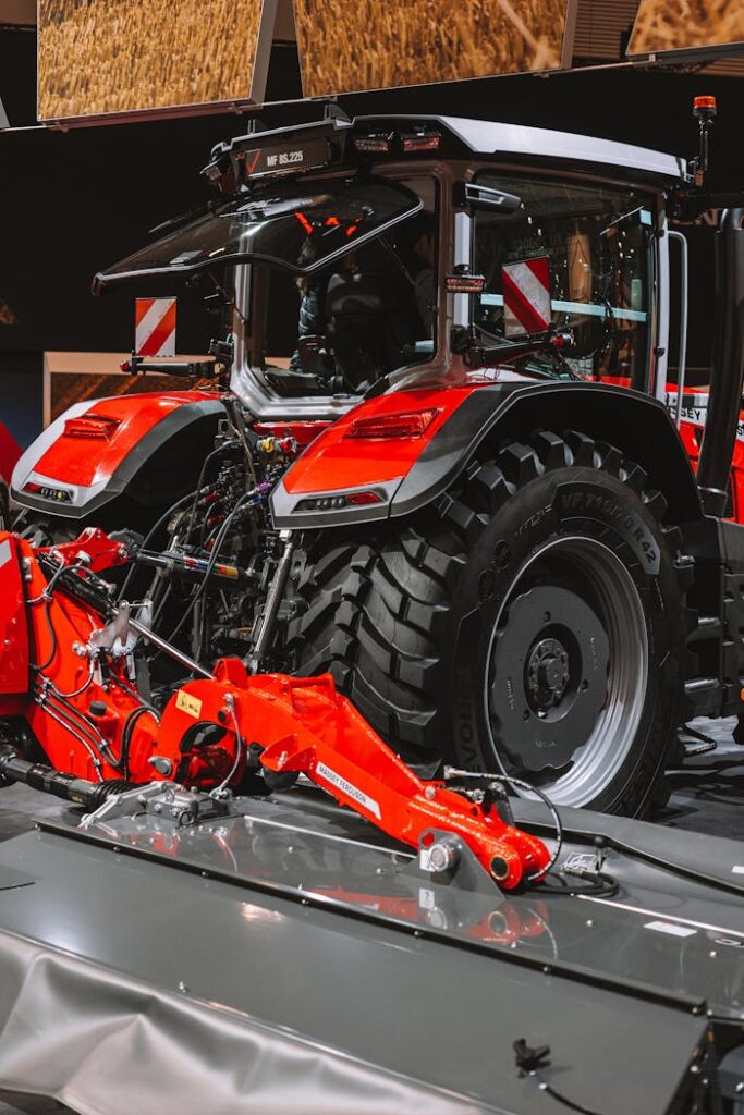 Modern red tractor parked indoors, showcasing farming technology and machinery.