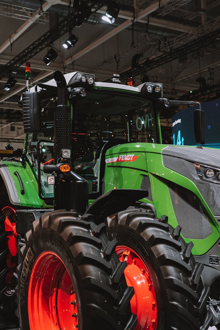 Close-up of a modern green tractor displayed indoors at a technology exhibition.